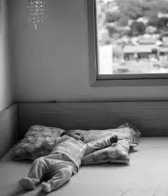 grayscale photo of person lying on bed